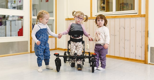 Mädchen im NF-Walker mit Spielkameraden